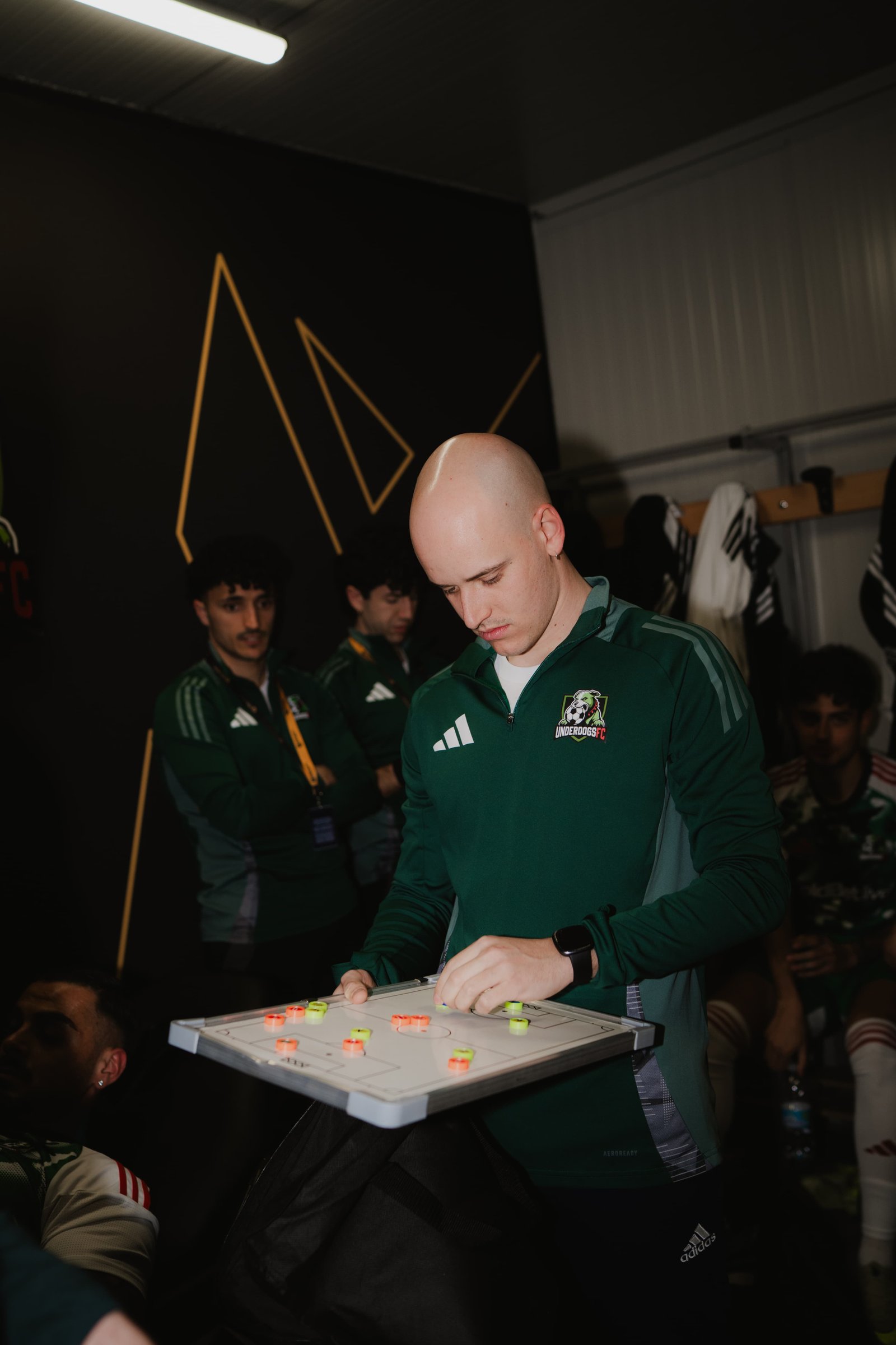 Gabriele Tentori, match analyst Underdogs FC, prepara l'analisi pre-gara con la lavagna tattica in spogliatoio